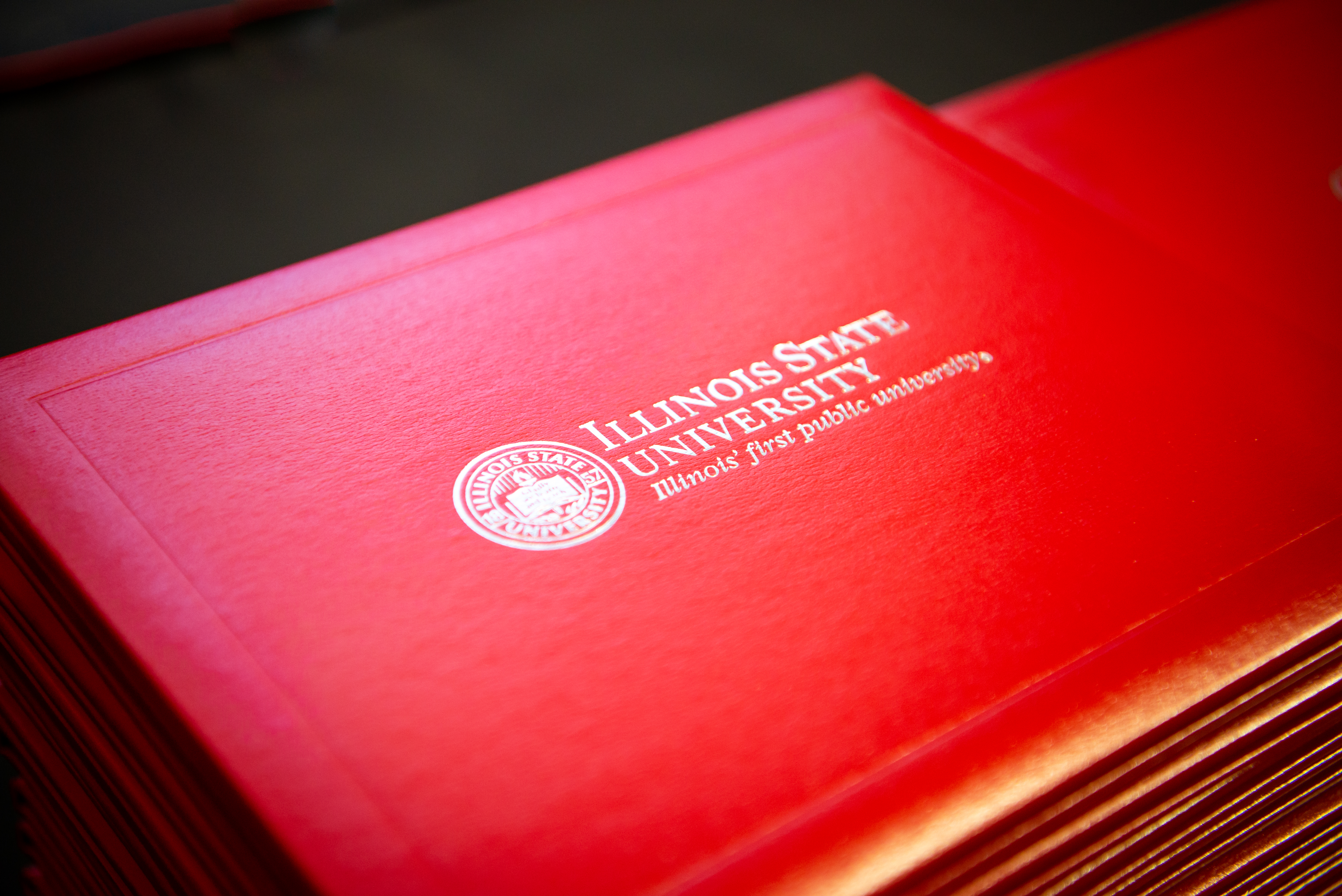 A neatly stacked pile of Illinois State University degrees.